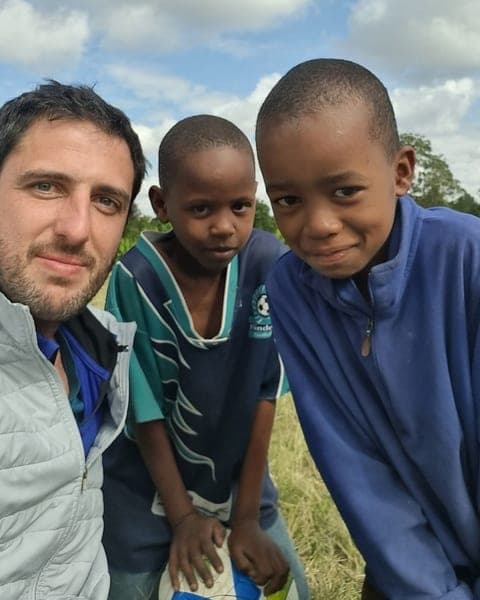 Nicolás Berhongaray, fundador de BADILI, junto a dos niños de una comunidad